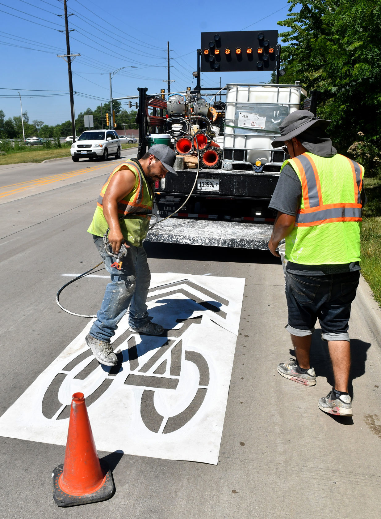 Painting of sharrows for bike lanes in Moline.
